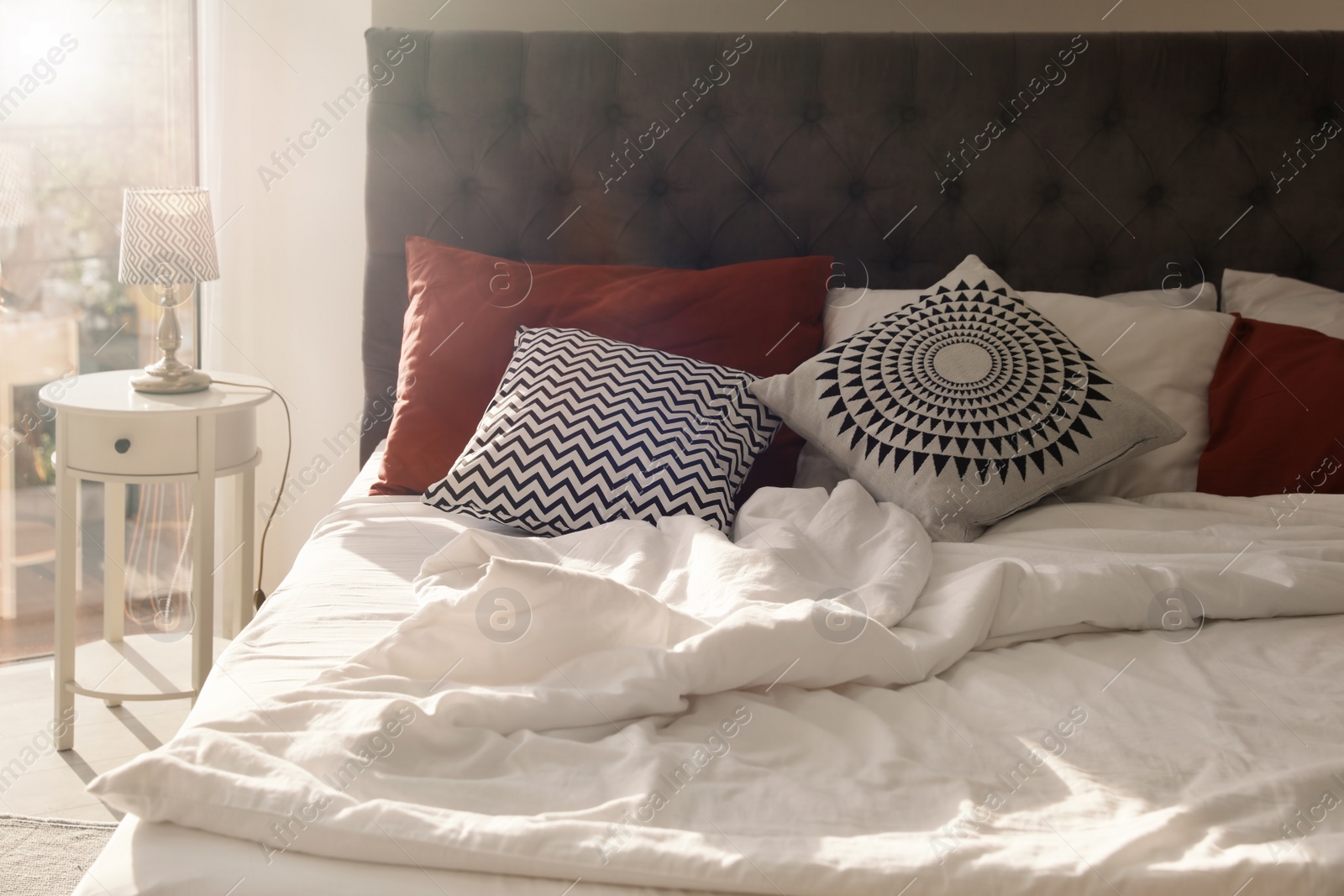 Photo of Different pillows on bed in room. Idea for interior decor