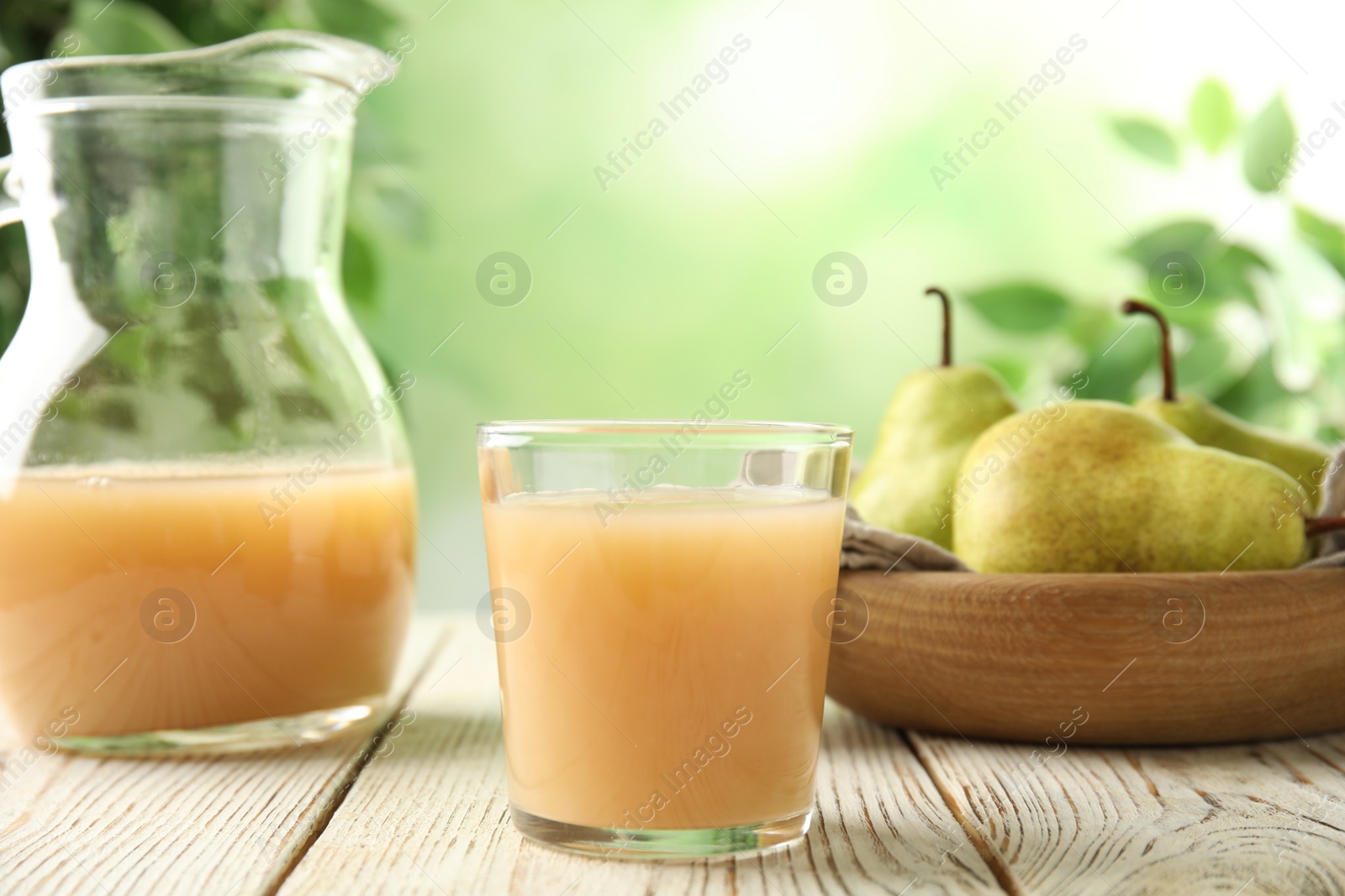 Photo of Fresh pear juice in glass on white wooden table, closeup