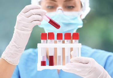 Scientist holding test tubes with blood samples in laboratory