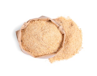 Photo of Fresh bread crumbs and paper bag on white background, top view