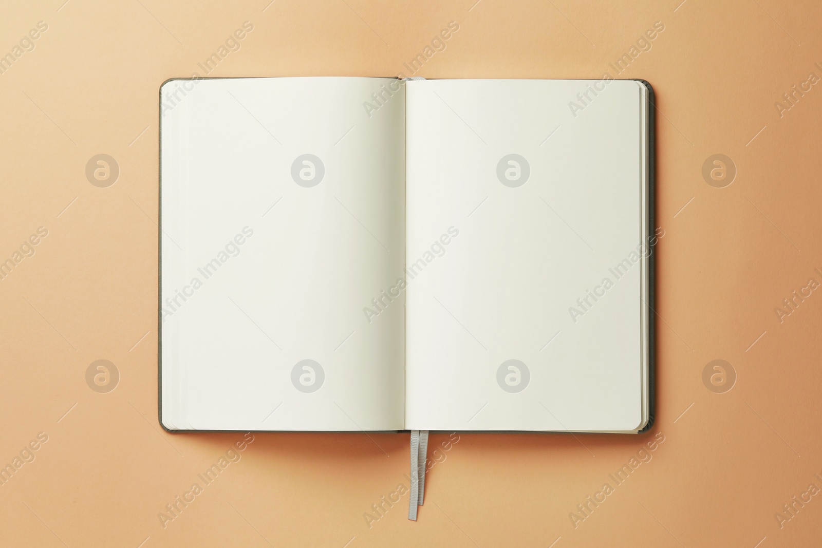 Photo of Open notebook on beige background, top view