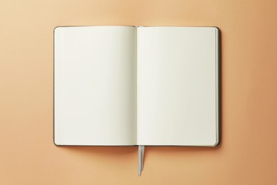 Photo of Open notebook on beige background, top view