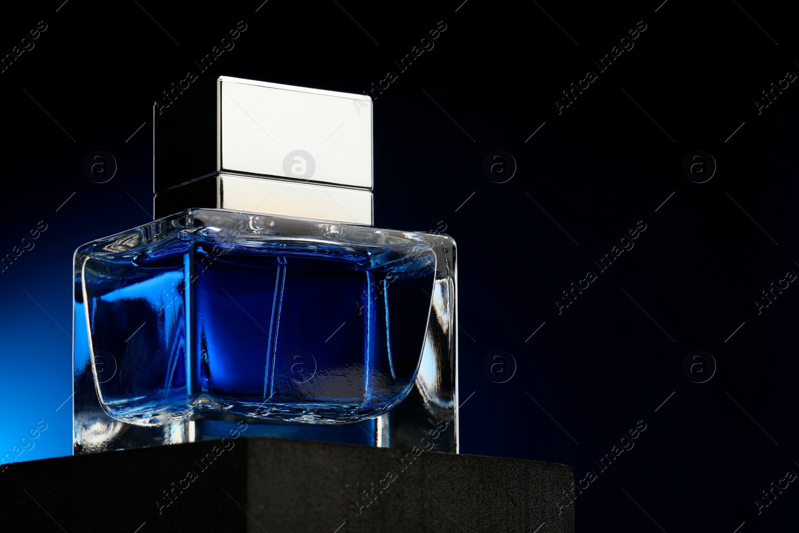 Photo of Luxury men`s perfume in bottle against dark background, space for text