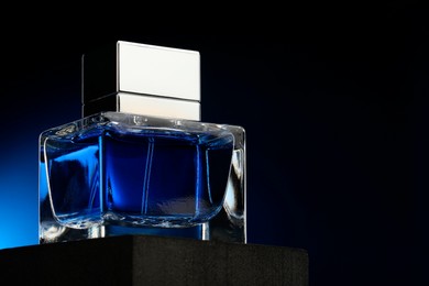 Photo of Luxury men`s perfume in bottle against dark background, space for text