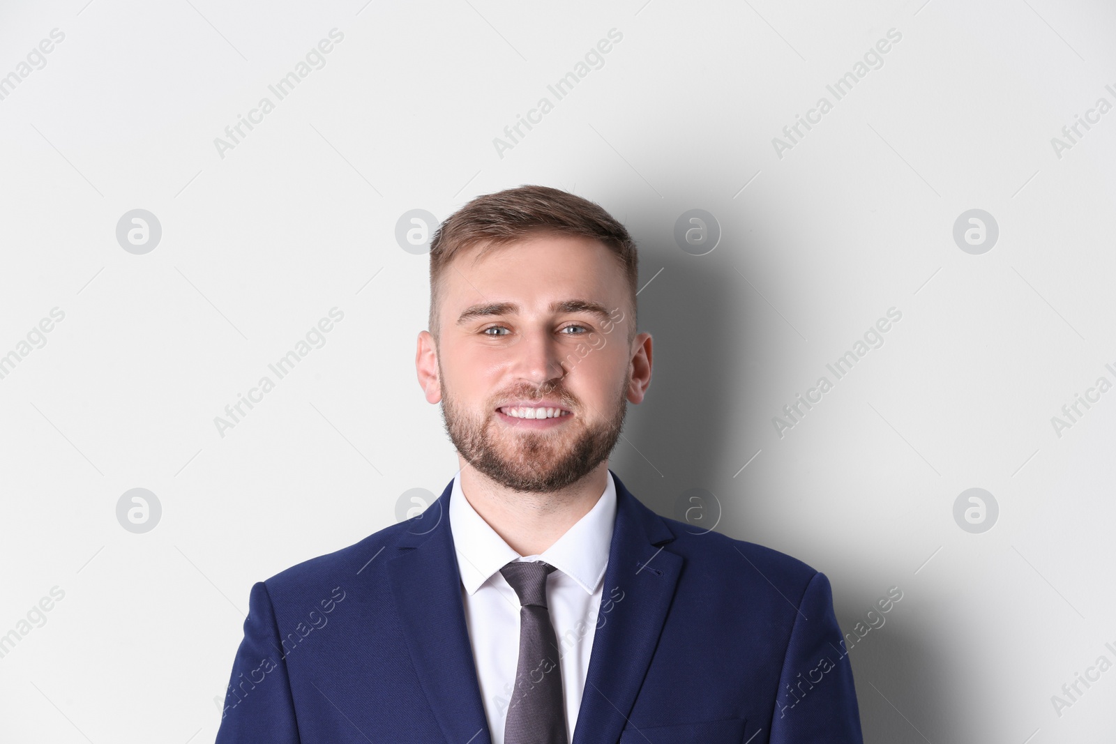 Photo of Portrait of happy man in office suit on white background