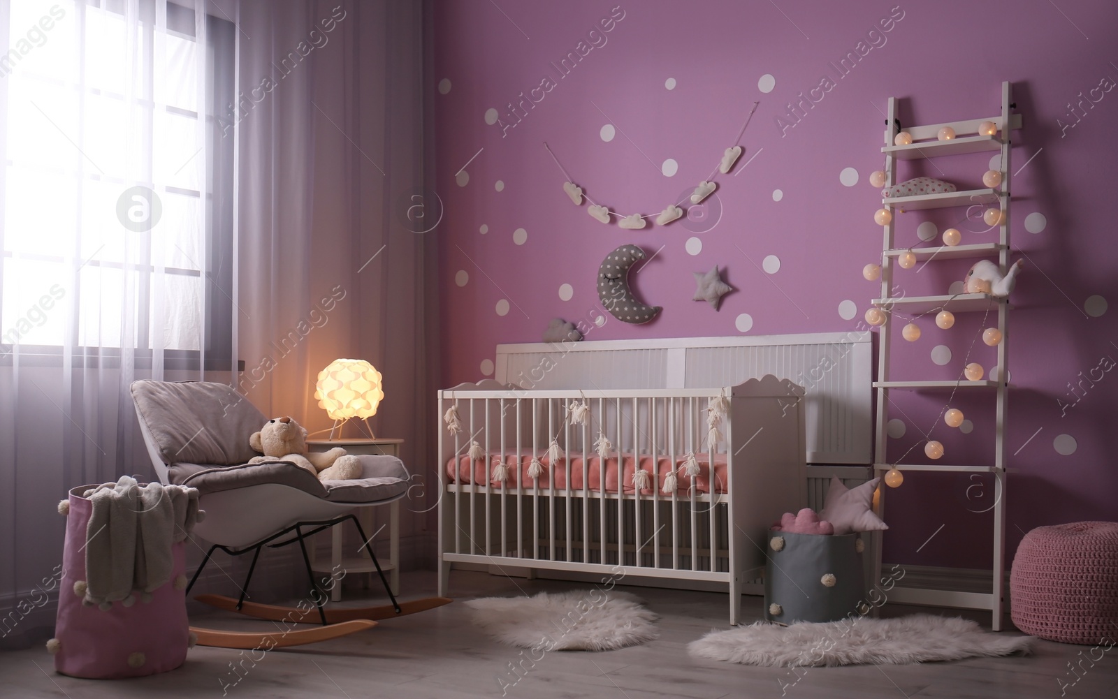 Photo of Baby room interior with crib near color wall