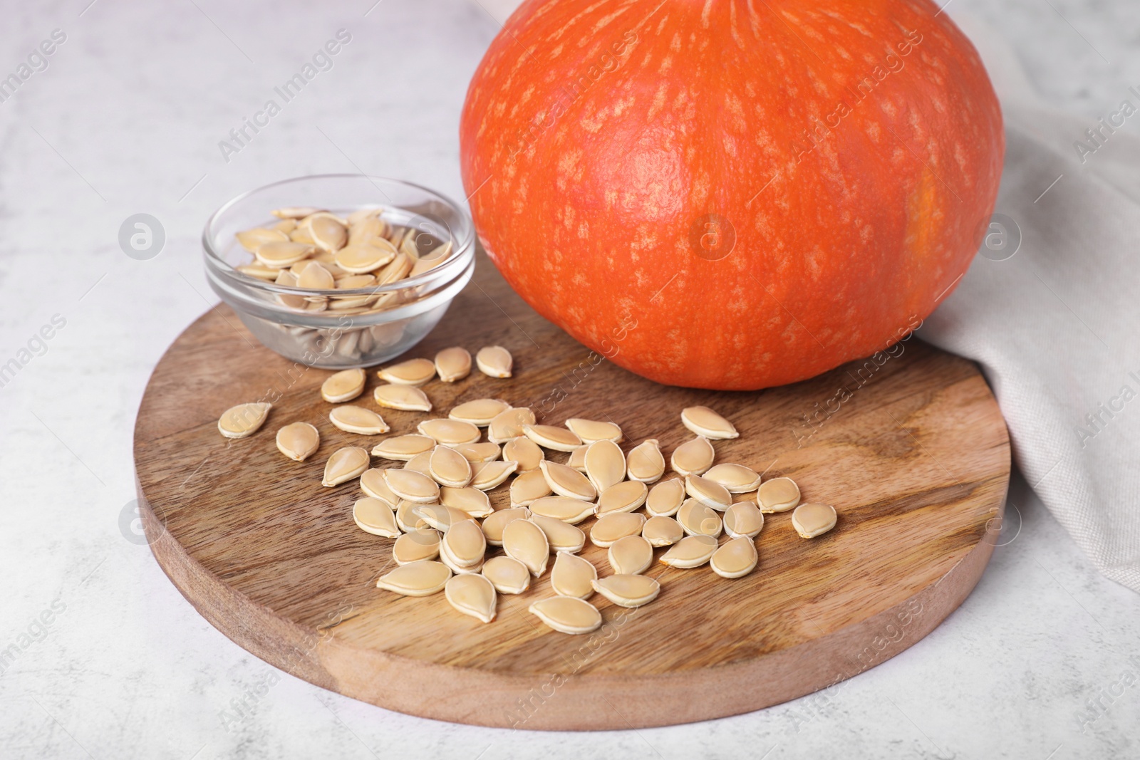 Photo of Fresh pumpkin and vegetable seeds on white table, closeup
