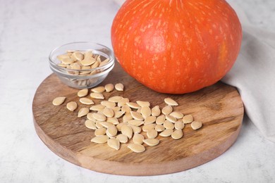 Fresh pumpkin and vegetable seeds on white table, closeup