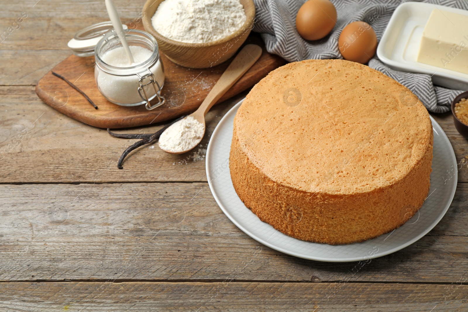 Photo of Delicious fresh homemade cake and ingredients on wooden table