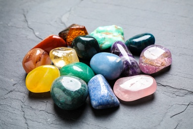 Photo of Pile of different precious gemstones on grey table