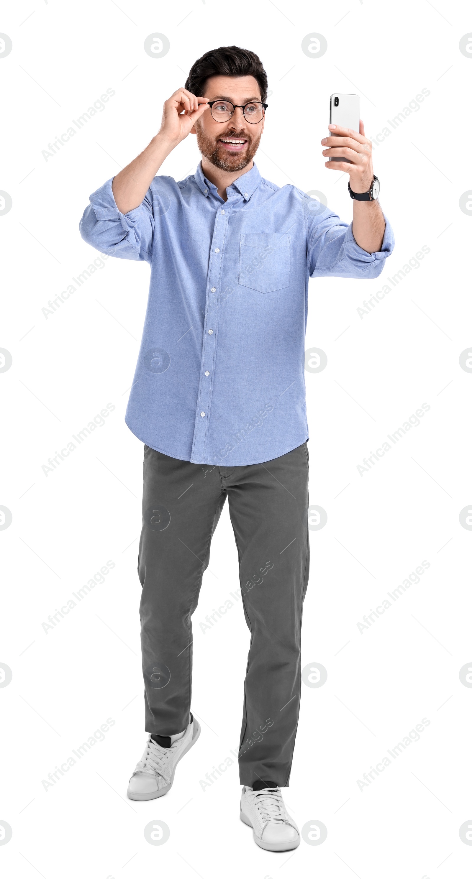 Photo of Smiling man taking selfie with smartphone on white background