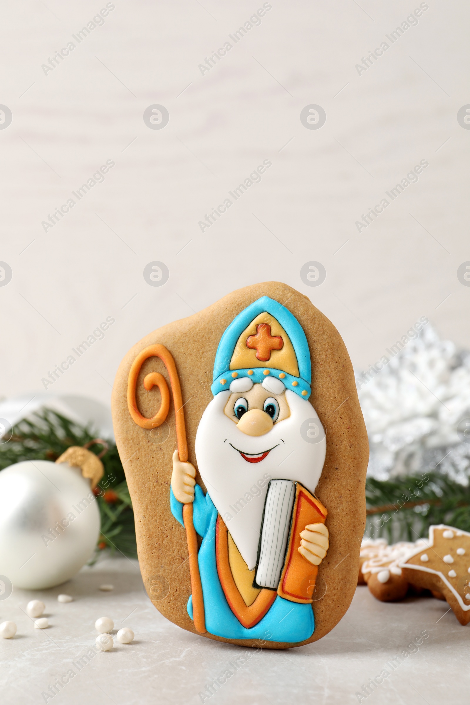 Photo of Tasty gingerbread cookie and festive decor on light table. St. Nicholas Day celebration