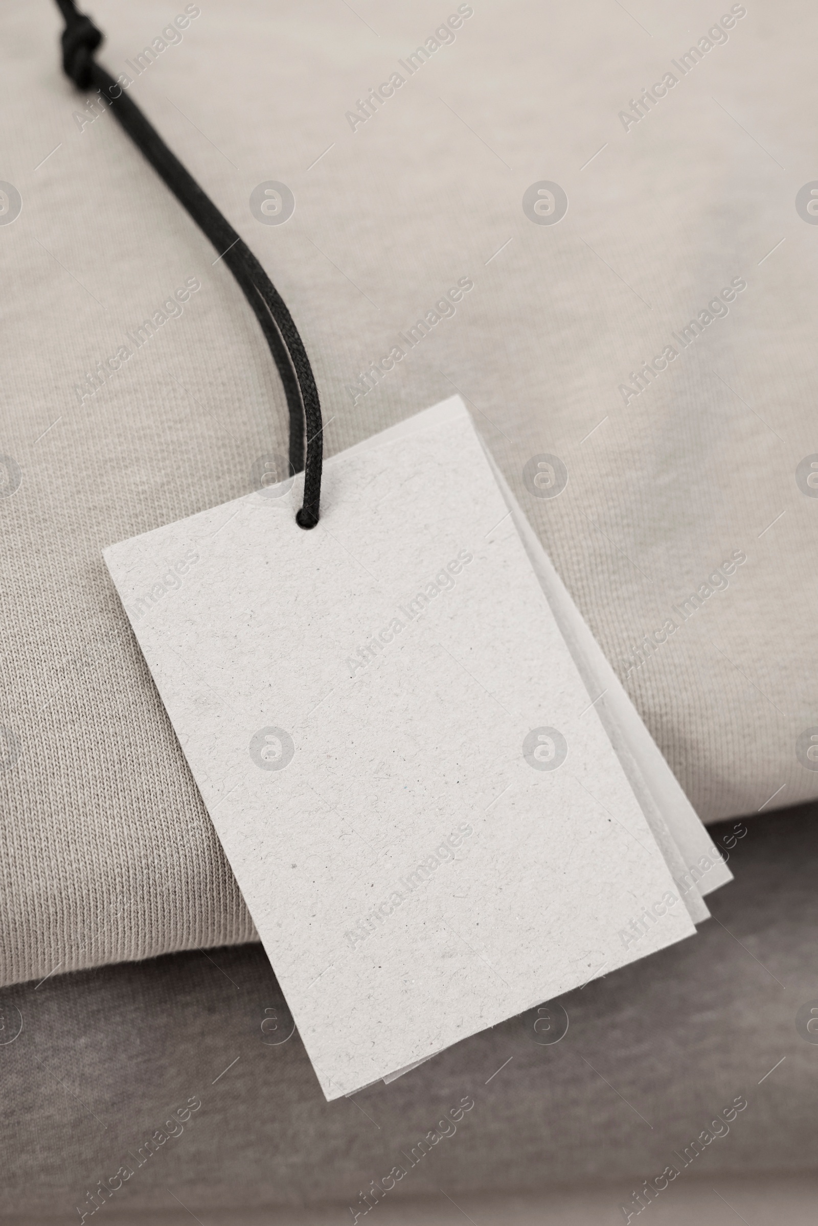 Photo of Garment with cardboard tag, closeup. Space for text