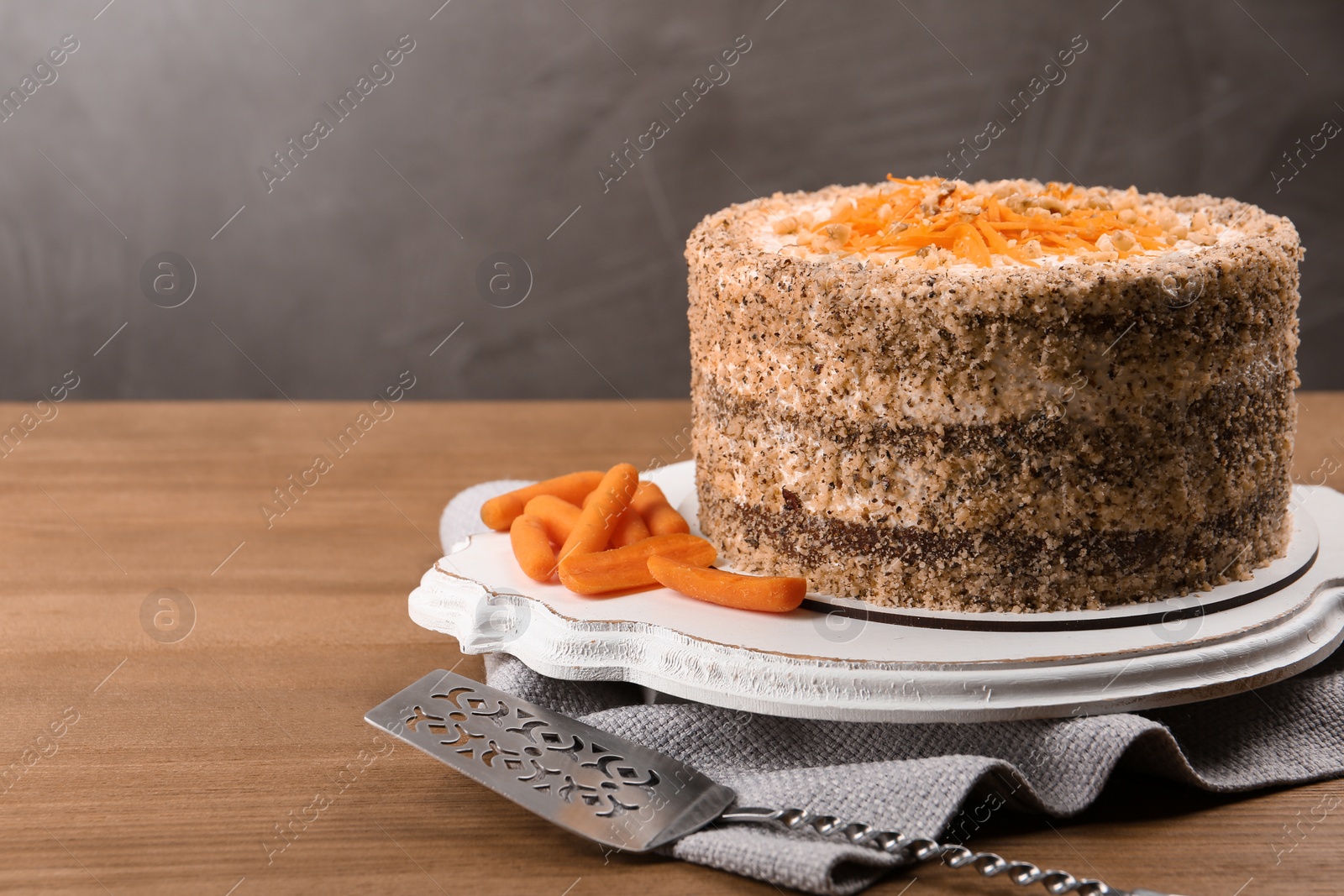 Photo of Sweet carrot cake with delicious cream on wooden table against color background. Space for text