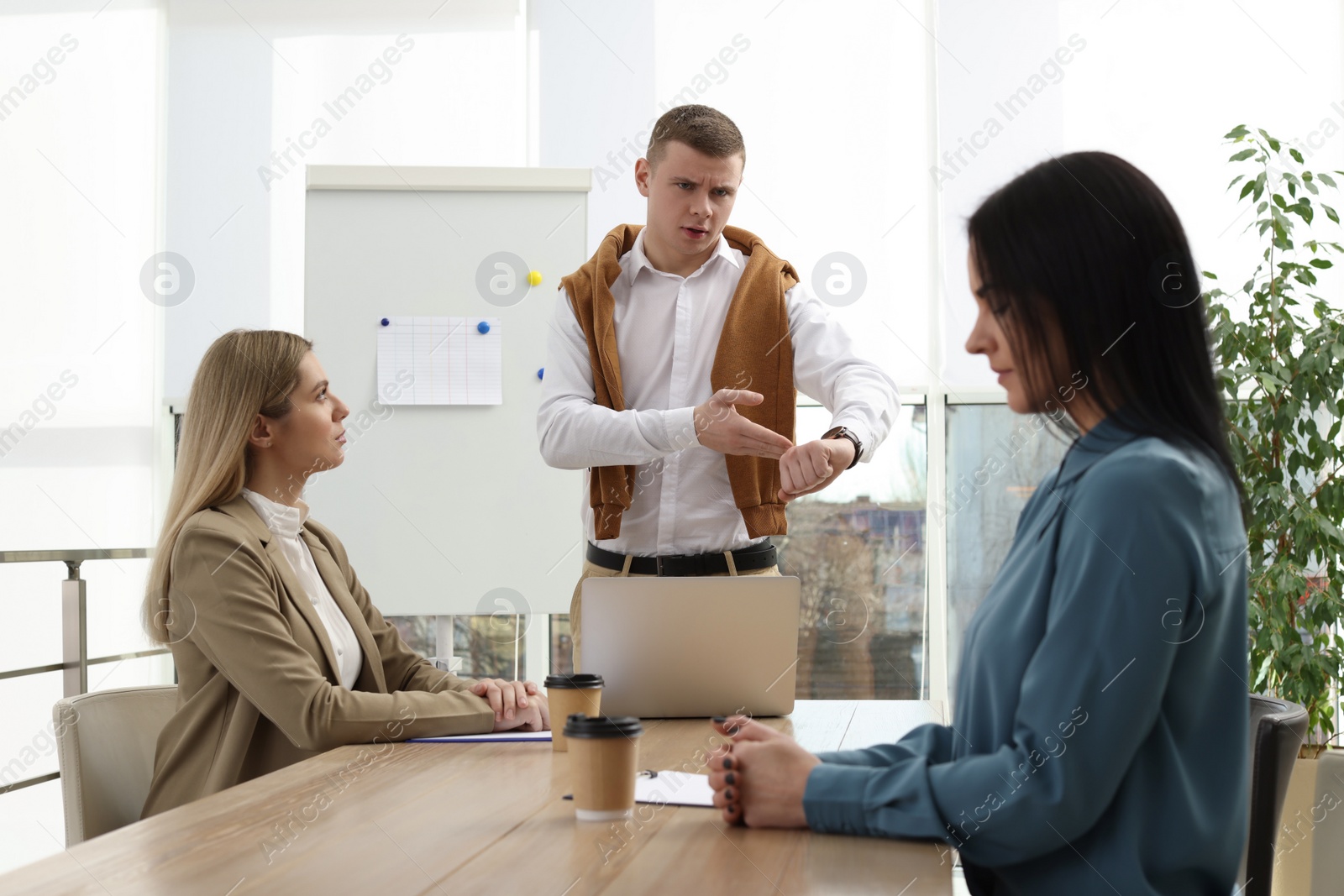 Photo of Businessman scolding employee for being late on meeting in office