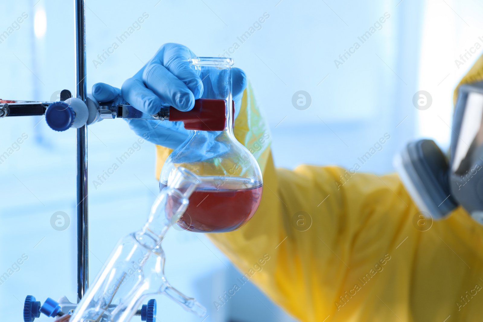 Photo of Scientist in chemical protective suit working at laboratory, closeup. Virus research