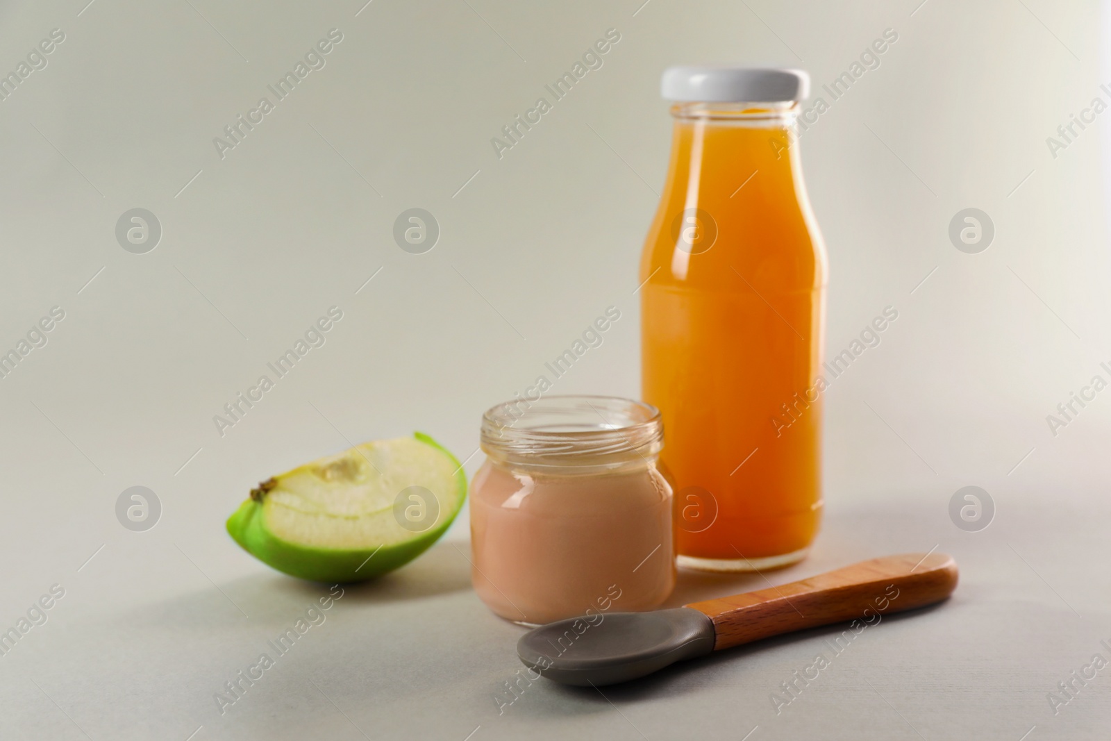 Photo of Healthy baby food, apple and juice on light grey background