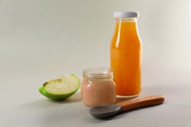 Healthy baby food, apple and juice on light grey background