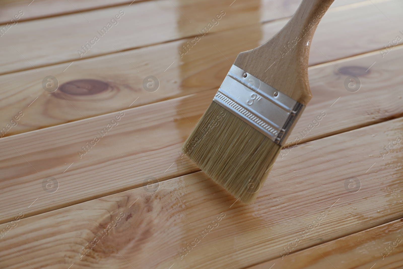 Photo of Varnishing wooden surface with brush, closeup view