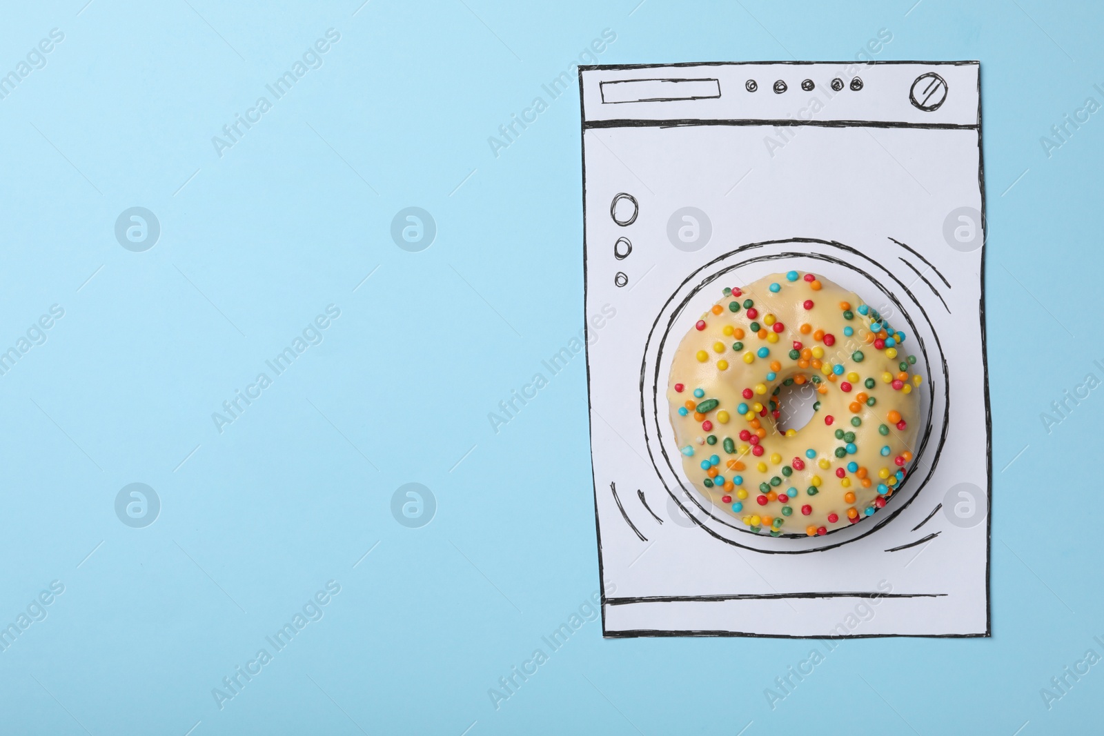 Photo of Washing machine made with donut and paper on light blue background, top view. Space for text