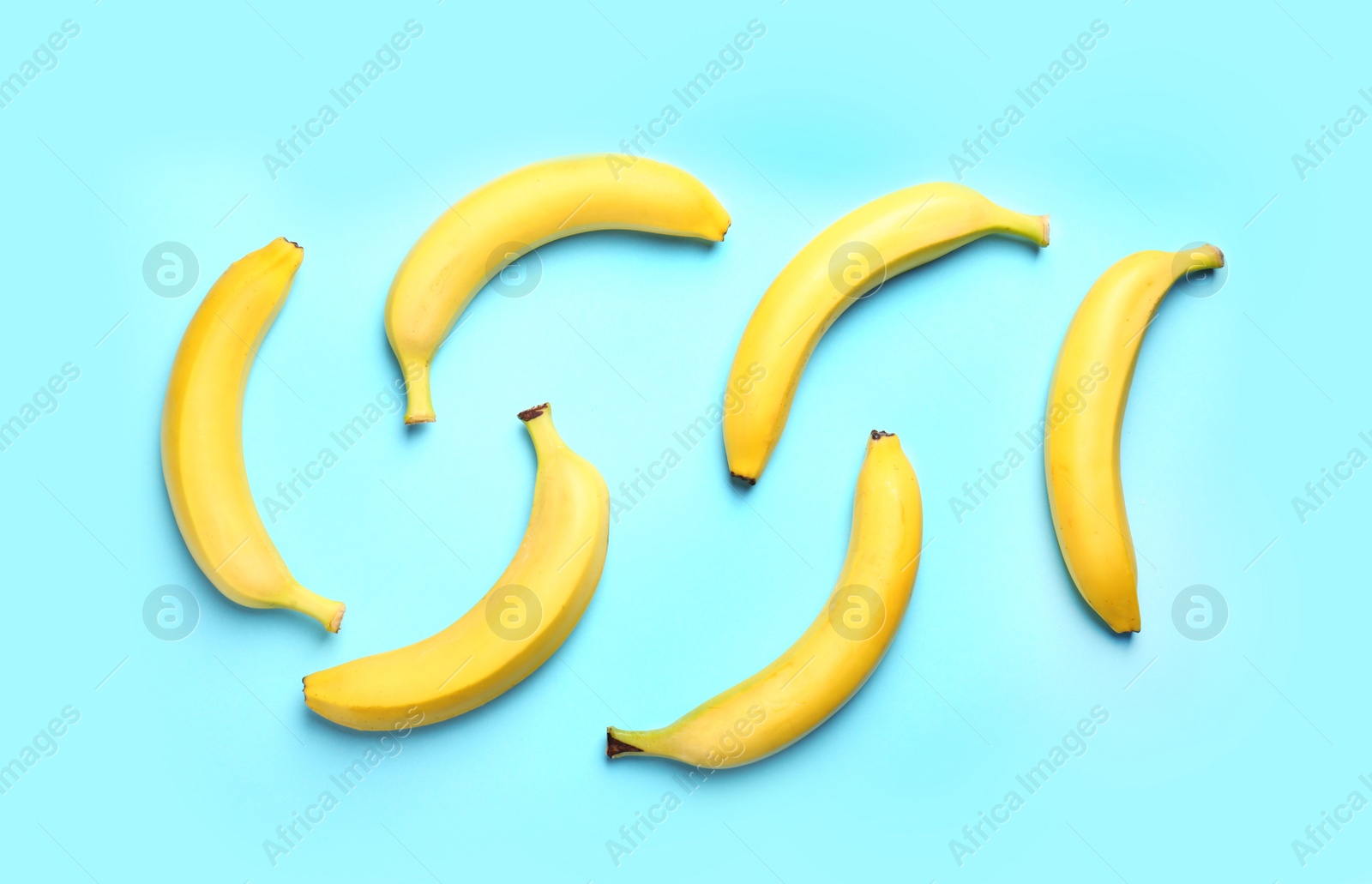 Photo of Ripe tasty bananas on blue background, flat lay