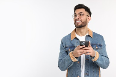 Happy young man using smartphone on white background, space for text