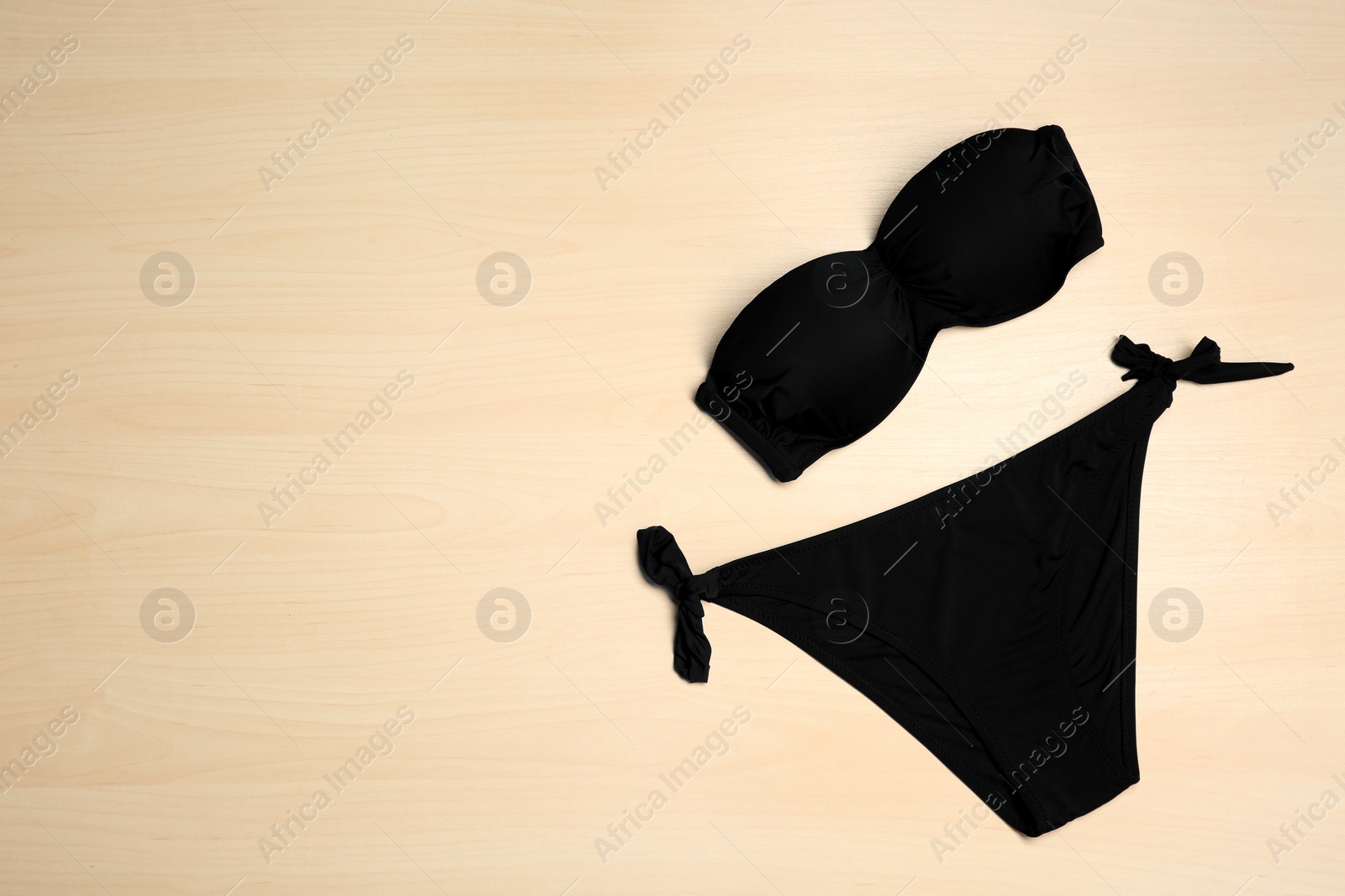 Photo of Stylish bikini on wooden background, flat lay. Space for text