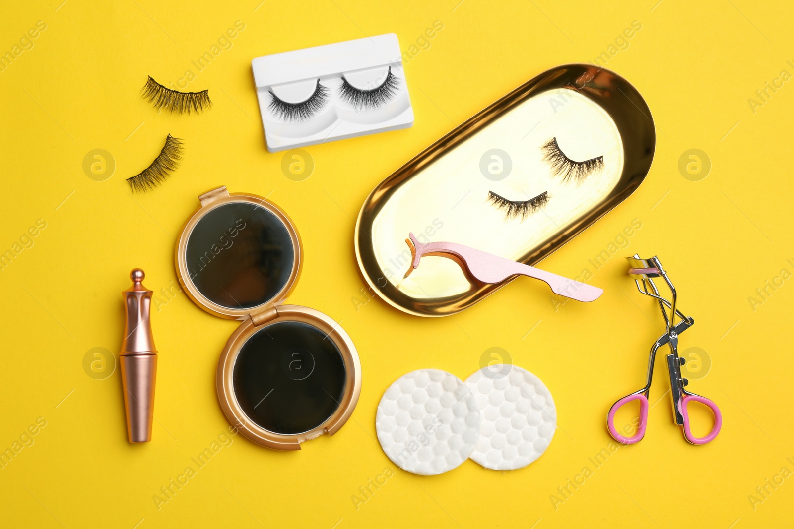 Photo of Flat lay composition with magnetic eyelashes and accessories on yellow background