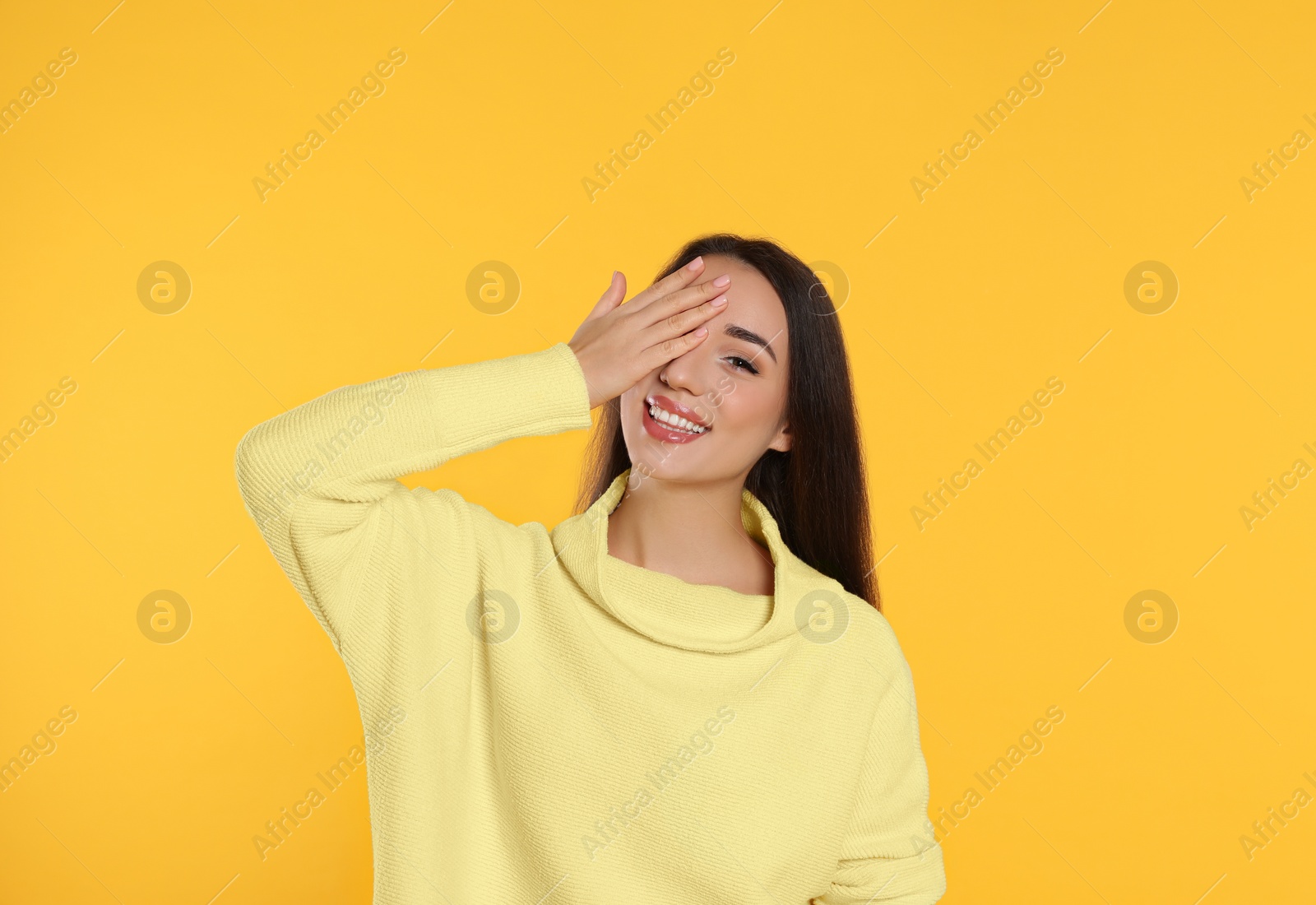 Photo of Beautiful young woman wearing warm sweater on yellow background