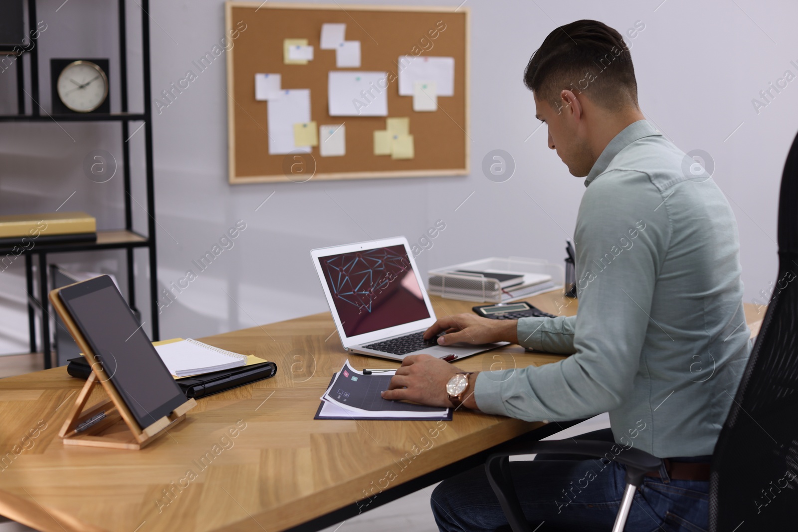 Photo of Businessman working with laptop and chart in office. Forex trading