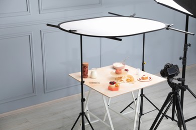 Photo of Professional equipment and composition with delicious desserts on wooden table in studio. Food photography