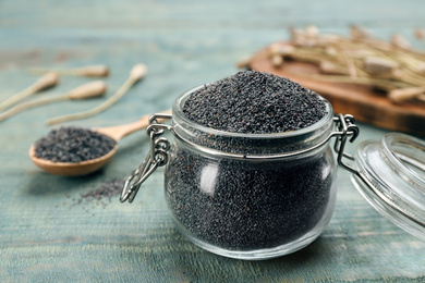 Poppy seeds in glass jar on blue wooden table