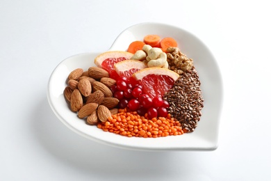 Plate with products for heart-healthy diet on white background