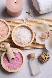 Flat lay composition with different spa products and orchid on light grey table