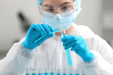 Photo of Scientist pouring sample into test tube in laboratory
