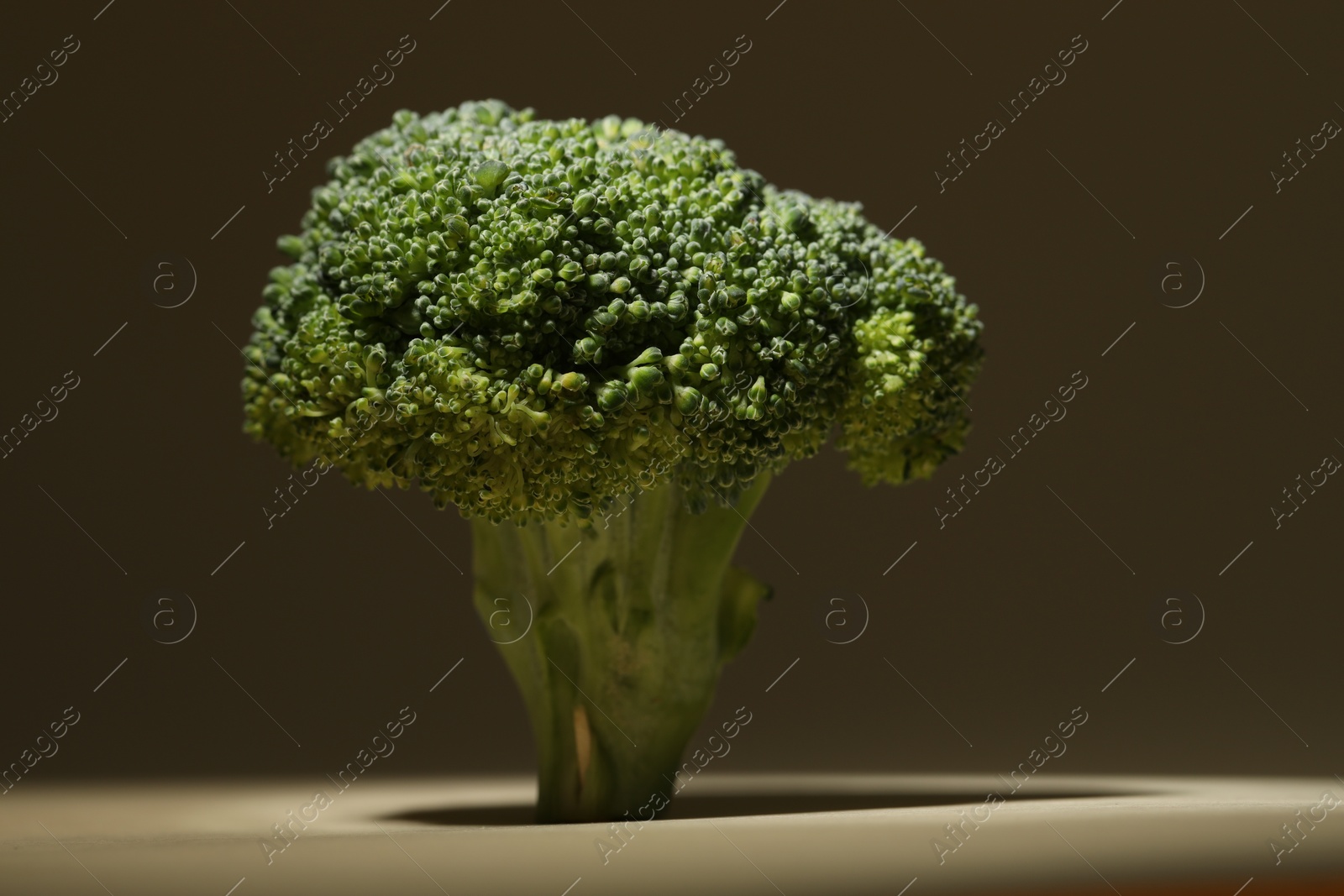 Photo of Fresh raw broccoli on beige background, closeup