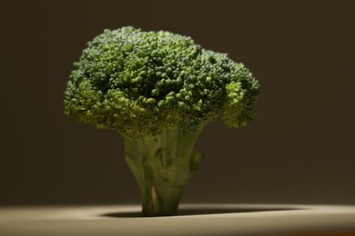 Photo of Fresh raw broccoli on beige background, closeup