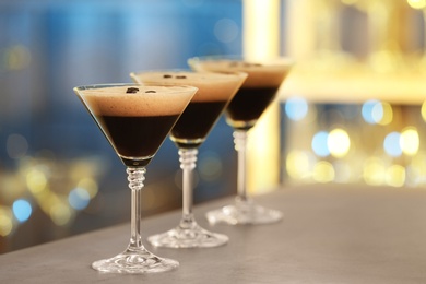 Photo of Glasses of delicious Espresso Martini on bar counter. Alcohol cocktail