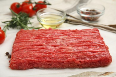 Photo of Raw fresh minced meat on white wooden table, closeup