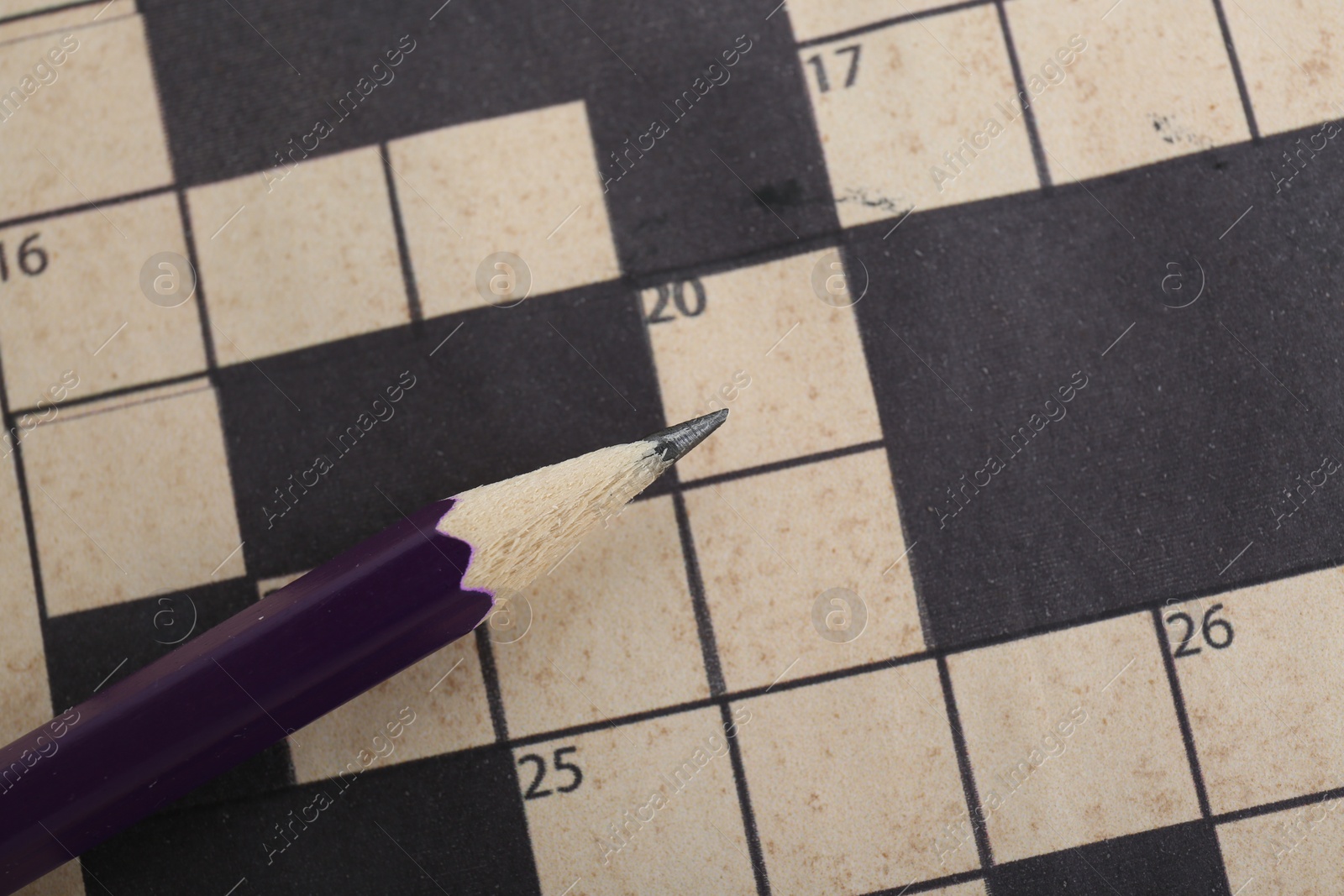 Photo of Pencil on blank crossword, top view. Space for text