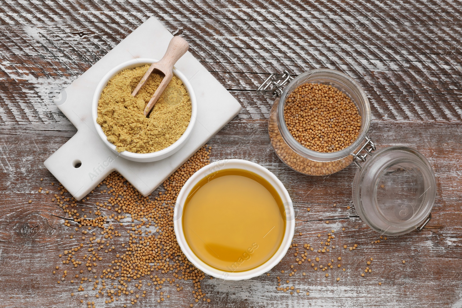 Bowl of natural oil, mustard seeds and powder on wooden table, flat lay Photo of Bowl of natural oil, mustard seeds and powder on wooden table, flat lay