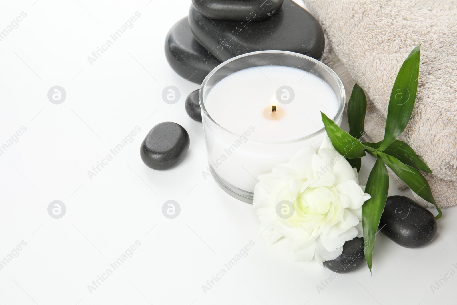 Photo of Beautiful spa composition with candle and stones on white background