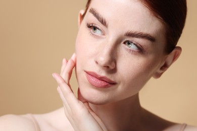 Portrait of beautiful woman on beige background, closeup