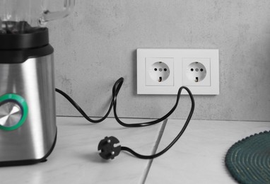 Photo of Power sockets and blender on white table