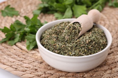 Photo of Dried aromatic parsley and fresh leaves on wicker mat, closeup. Space for text