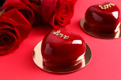 St. Valentine's Day. Delicious heart shaped cakes and roses on red background, closeup