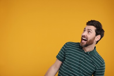 Photo of Portrait of surprised man on yellow background, space for text