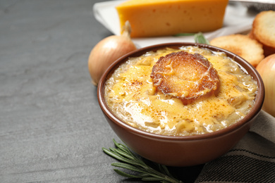 Photo of Tasty homemade french onion soup served on black table