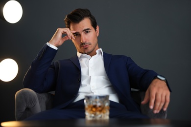 Young man with glass of whiskey indoors