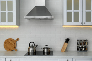 Kettle and saucepan on cooktop in modern kitchen